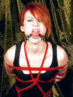 Redhead roped standing and ball-gagged